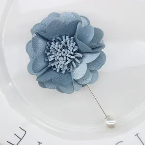 Detail of blue fabric flower brooch with long needle pin and elegant pearl accent
