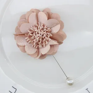 Detailed view of champagne pink fabric flower brooch with long pin and white pearl tip
