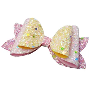 Macro detail of sequin bow accessory with pink and yellow gradient glitter finish