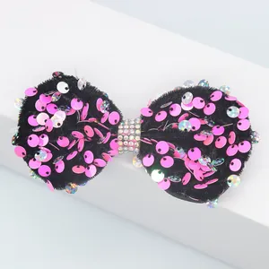 Détail d'un nœud en velours avec paillettes roses et centre en strass étincelant