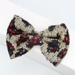 Dettaglio di fiocco di paillettes con motivo leopardato per capelli e scarpe