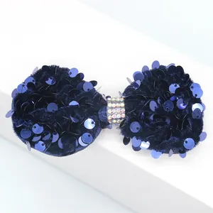 Détail du nœud en velours bleu marine avec paillettes brillantes et strass centraux