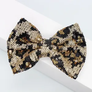 Dettaglio del fiocco con paillettes leopardate e trama glitterata in oro e nero lucido