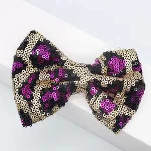 Dettaglio di un fiocco di paillettes con motivo leopardato nero oro e viola per accessori