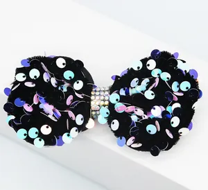 Détail d'un nœud en velours avec paillettes irisées et centre en strass cristallins