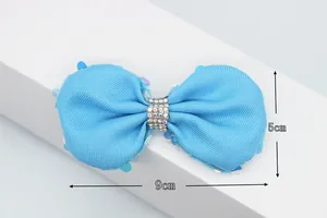 Nœud en velours bleu clair avec paillettes et strass, dimensions 9cm par 5cm