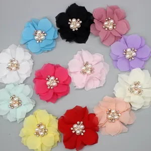 Flat lay of 12 colorful chiffon DIY flower accessories with pearl and rhinestone centers