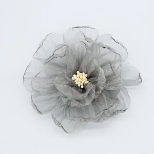 Dettaglio di una spilla a peonia in chiffon grigio multistrato con trama fatta a mano