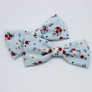 Détail de deux nœuds en mousseline bleu clair avec motifs de fleurs rouges pour bricolage