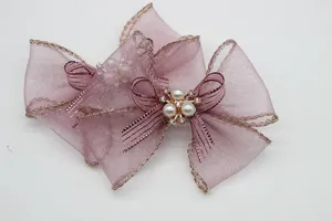 Dettaglio di fiocchi in organza lavanda con bordo dorato, perle e strass lucidi