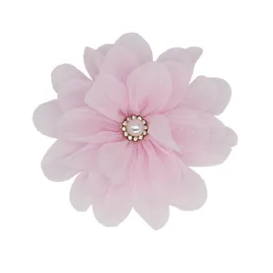 Macro detail of a handmade pink chiffon flower with a pearl and rhinestone center