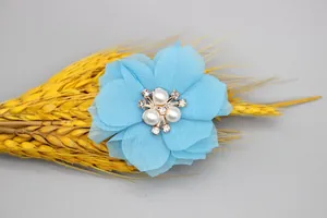 Close-up of 6cm light blue chiffon fabric flower with central pearls and rhinestones
