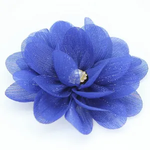 Close-up of deep blue chiffon flower with mesh petals, central pearl and glitter