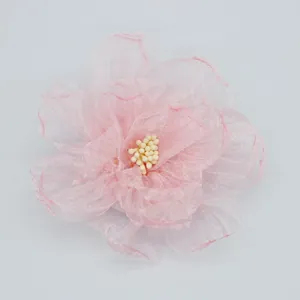 Gros plan détaillé sur une pince à fleur en organza rose avec pétales et étamines perlées