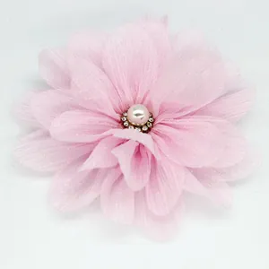 Detail of pink chiffon fabric flower with multilayered petals and a pearl rhinestone center