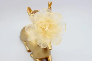 Dettaglio macro di un fiore in organza giallo pallido da 9 cm con petali stratificati