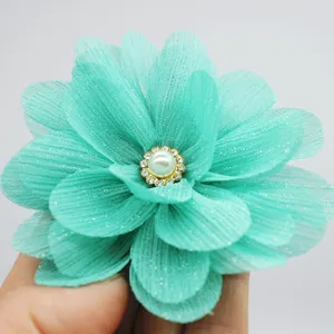 Detailed view of turquoise chiffon flower hair clip with pearls and sparkling rhinestones