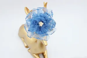 Dettaglio di fiore di peonia in organza blu con centro di perline su supporto