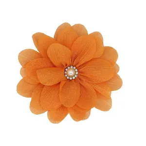 Vue détaillée de la fleur en mousseline orange avec perle et strass brillants