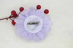 Detail of the back assembly showing the silver safety pin on the light purple fabric flower