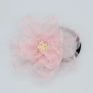 Detailweergave van de roze zijden bloem haarband met delicate organza bloemblaadjes en elastiek