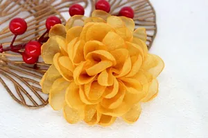 Macro detail of yellow organza flower brooch with elegant gold glittered petal edges