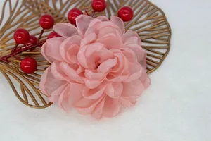 Detail of pink organza fabric flower with layered petals on a gold decorative tray