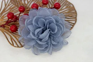 Close-up of a handcrafted blue organza flower brooch with detailed layered petals
