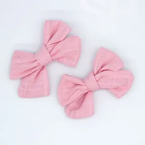 Close-up of pink linen texture bow hair accessories for DIY crafts and baby socks