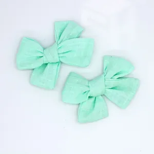 Detail view of two mint green linen bow hair accessories for kids DIY projects