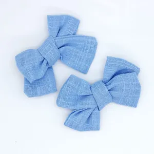 Detail of sky blue linen-textured bow accessories with intricate woven fabric details