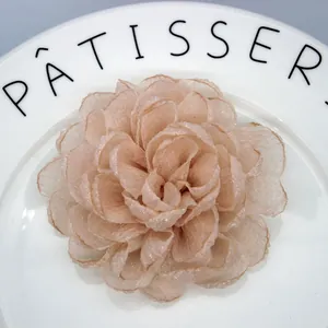 Close-up of handmade organza peony hair clip with layered petals and shimmering edges
