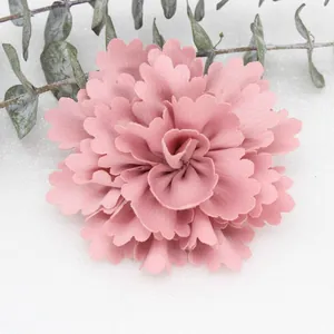 Detail of a dusty pink handmade fabric flower with multi-layered pleated chiffon petals