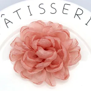 Detailed macro view of handmade pink organza peony flower hair clip with layered petals