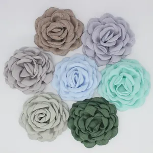 Detailed overhead view of multicolored fabric rose hair clips in 7 various colors