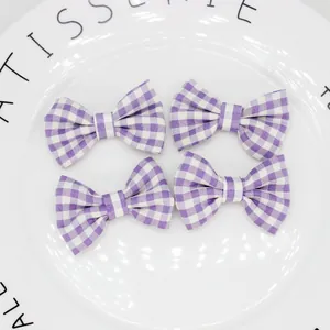 Dettaglio di quattro fiocchi in tessuto a quadretti viola e bianchi per capelli fai-da-te