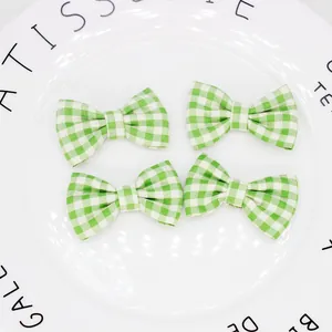 Dettaglio di quattro fiocchi in tessuto a quadretti bianchi e verdi su piatto decorativo