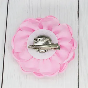 Detail of pink fabric rose brooch with silver dual-function clip and pin backing