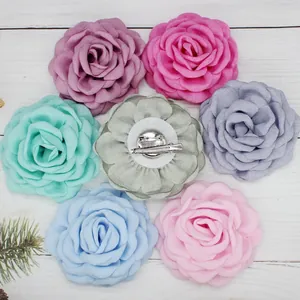 Detailed back view of fabric flower hair clip showing dual metal pin and alligator clip