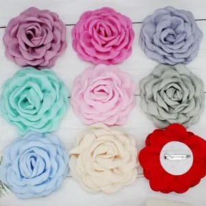 Detail showing the metal safety pin and non-woven base on fabric floral brooches