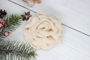 Detailed close-up of a handmade cream fabric peony flower with multi-layered soft petals