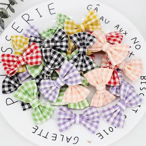 Accessori a fiocco in tessuto vichy colorato presentati su un piatto di ceramica bianca