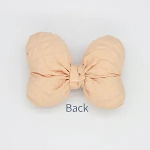 Detailed back view of apricot padded fabric bow with checkered texture and hand sewing
