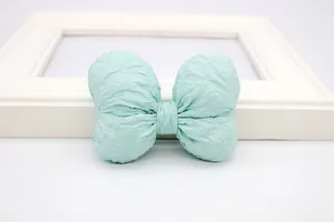 Detailopname van een muntgroene stoffen strik met unieke geplooide textuurafwerking