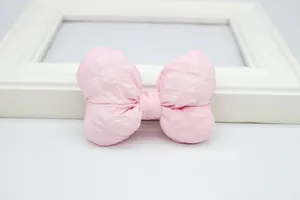 Detailopname van roze gewatteerde stoffen strik met stikseltextuur voor kinderkleding