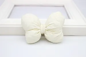 Detailopname van een crèmewitte stoffen strik met wafelpatroon en zachte katoenen vulling