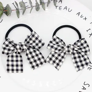 Detailaufnahme von schwarz-weißen Gingham-Haarschleifen auf weißem Zierteller