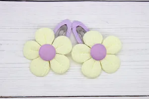 Detail of yellow fabric sunflower hair clips with purple ribbon wrap for kids