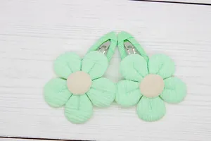 Detail of mint green fabric flower hair clips with textured petals and center button