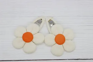 Detail of cream fabric sunflower hair clips for girls with bright orange centers